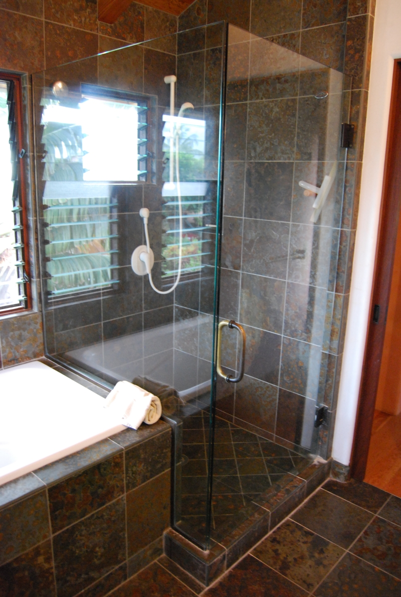A glass enclosed walk in shower in the master bathroom